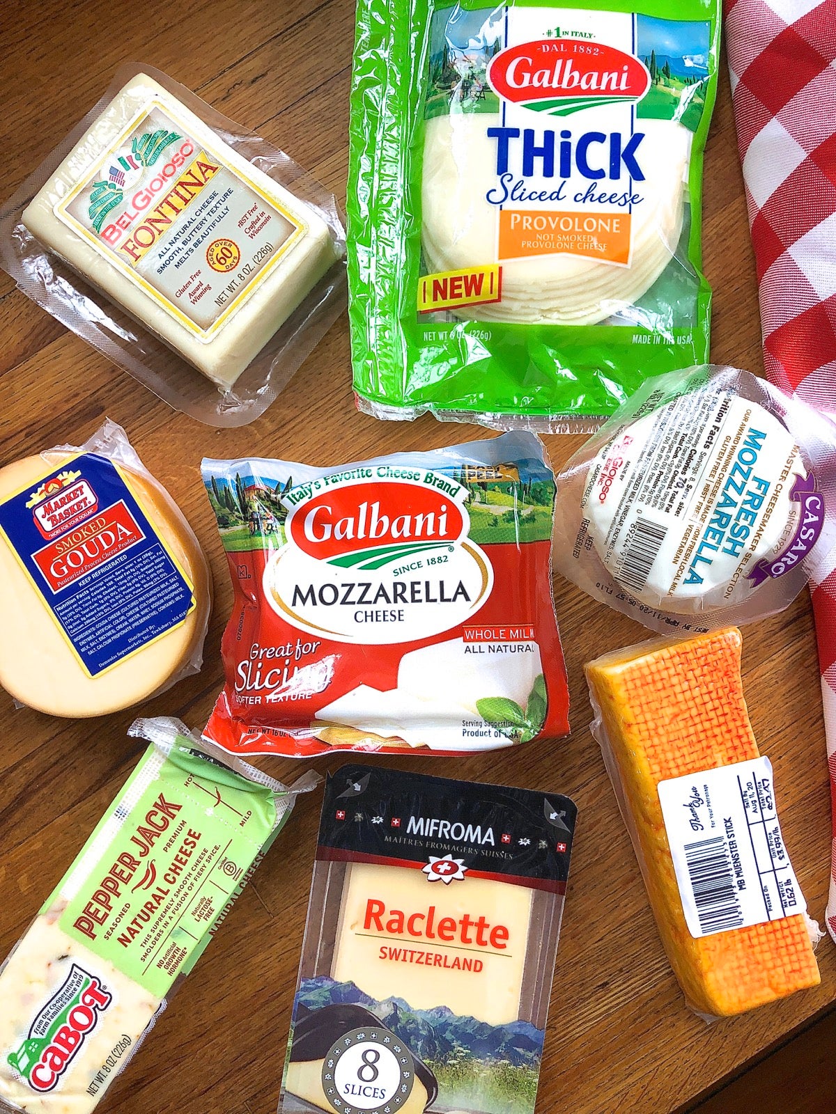 Eight different pizza cheeses arrayed on a countertop.